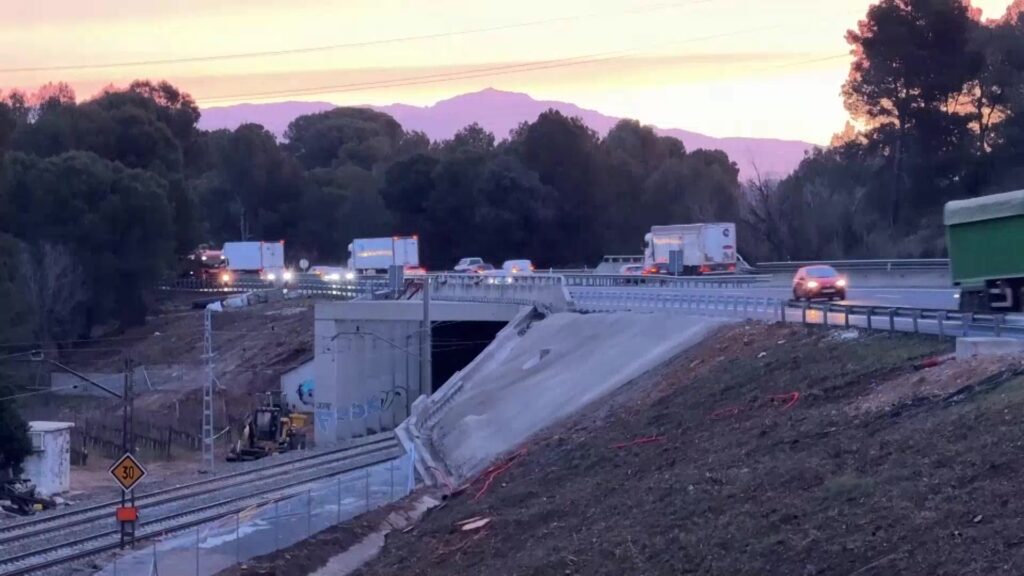 Vehicles circulant per l'autopista AP-7 al seu pas per Gelida amb el talús ja estabilitzat.