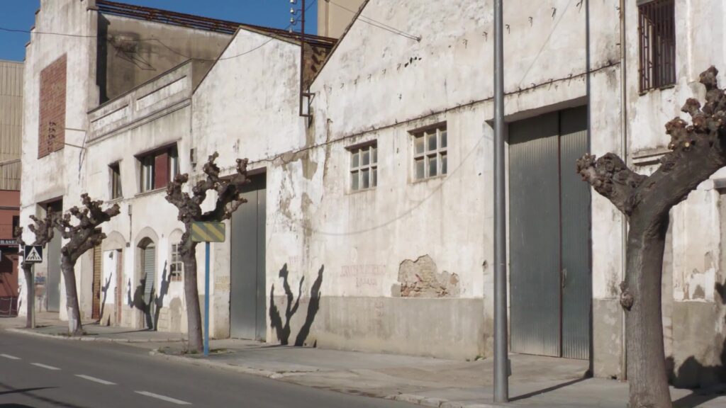 Edificis antics i magatzems degradats al carrer de la façana fluvial d'Amposta, Montsià.