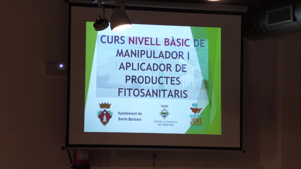 Pantalla de projecció amb el títol del curs de fitosanitaris al Museu de la Vida a la Plana de Santa Bàrbara, Montsià.