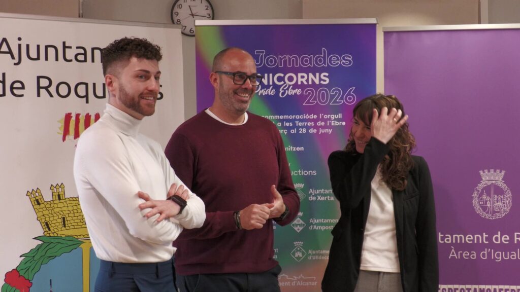 Presentació oficial de les jornades Unicorps Pride Ebre 2026 a l'Ajuntament de Roquetes amb els organitzadors davant del cartell promocional.