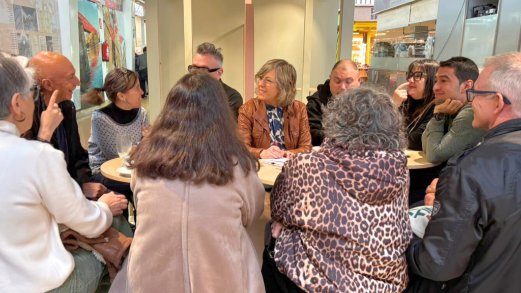 Mar Lleixà reunida amb un grup de veïns i veïnes en una taula al Mercat Municipal de Tortosa.