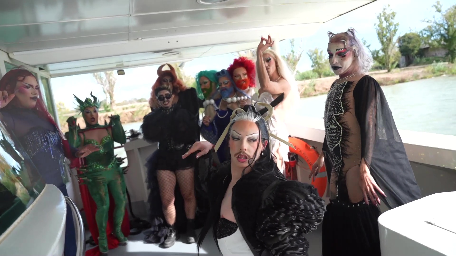 Grup d'artistes drag de Delta Drag posant amb vestuaris creatius a la coberta de "la Perla" a Amposta.