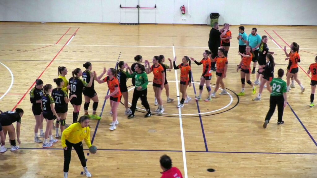 Jugadores del Club Handbol Amposta i l'Handbol Sant Vicenç saludant-se a la pista del pavelló municipal d'Amposta, Montsià.