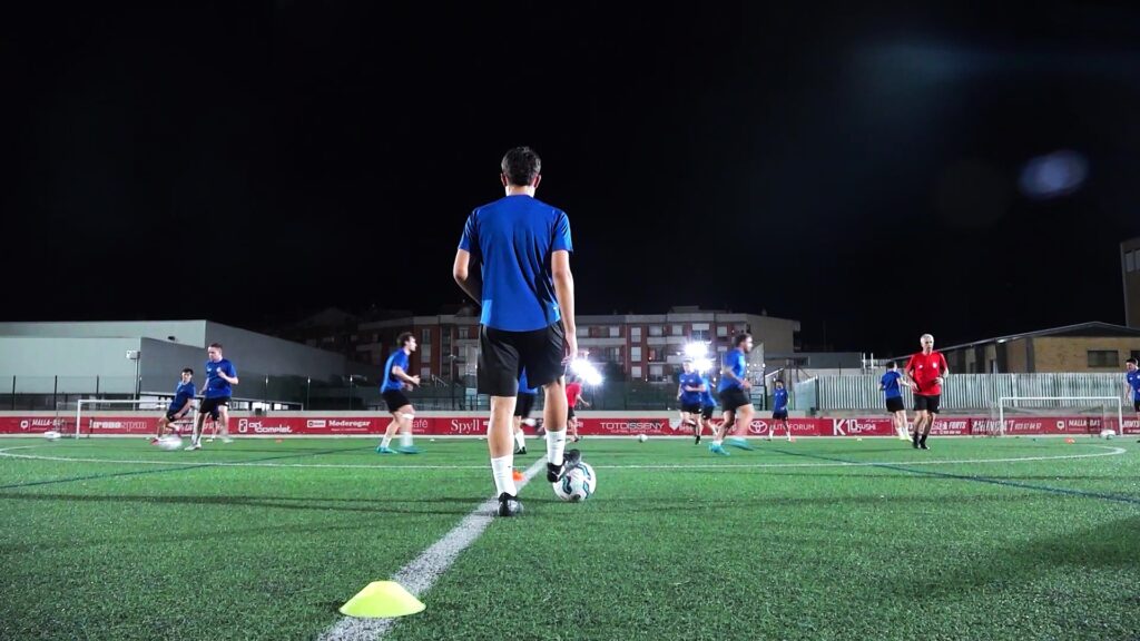 Jugadors del Tortosa-Ebre CF durant una sessió d'entrenament nocturna al camp de futbol de Tortosa, Baix Ebre.