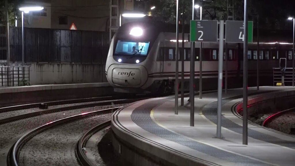 Tren de Renfe arribant a l'estació de l'Aldea-Amposta-Tortosa a les Terres de l'Ebre durant la nit.