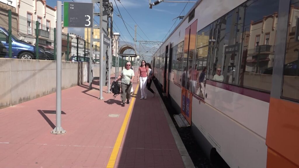 Passatgers caminant per l'andana de l'estació de tren de l'Aldea a les Terres de l'Ebre.
