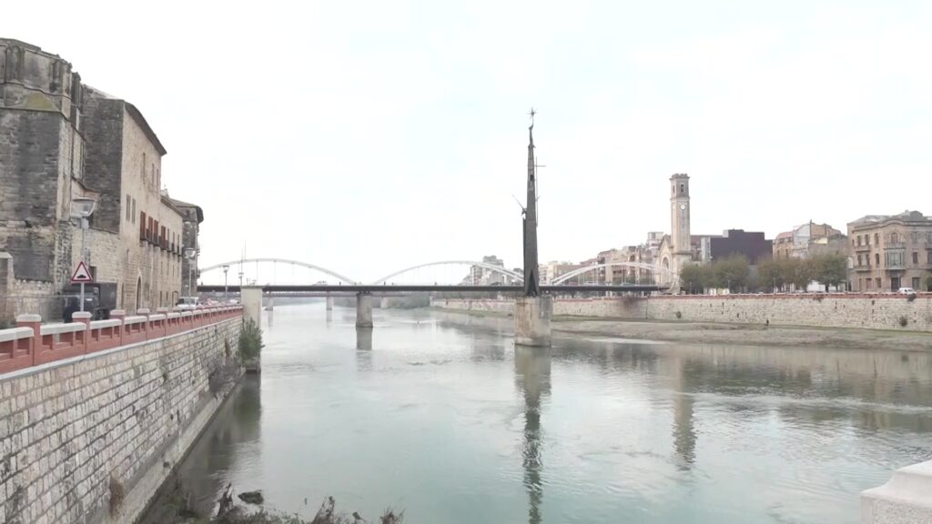 Monument franquista de Tortosa situat al mig del riu Ebre amb el pont de l'Estat al fons.