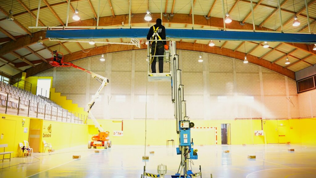 Treballadors realitzant el canvi de llums a tecnologia LED al pavelló municipal de Deltebre, Baix Ebre.