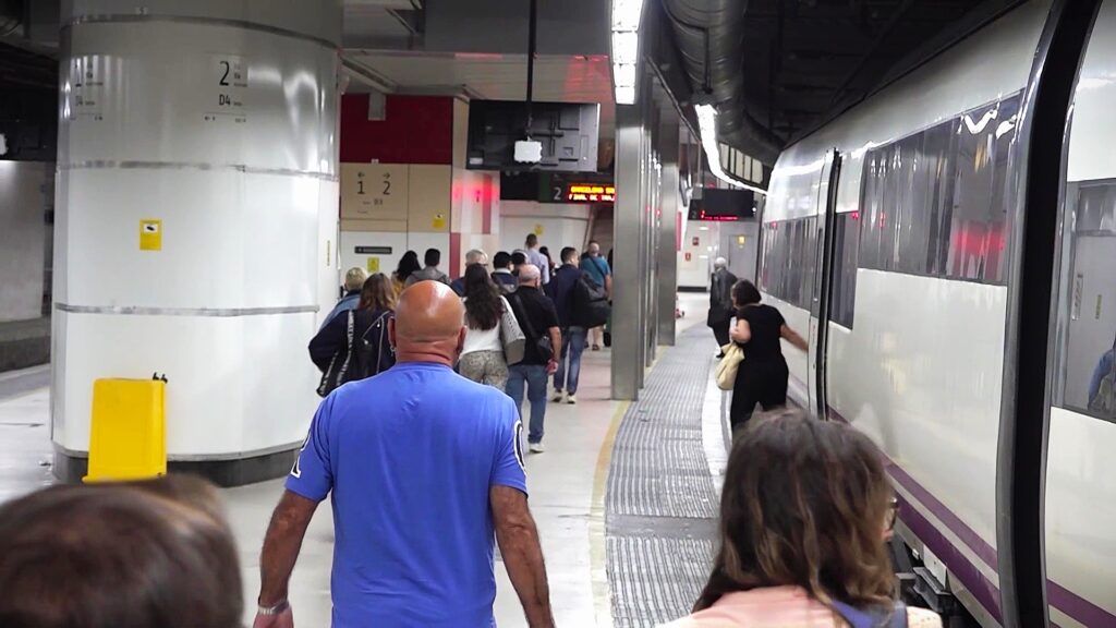 Passatgers caminant per l'andana de l'estació de Tortosa al costat d'un tren Avant