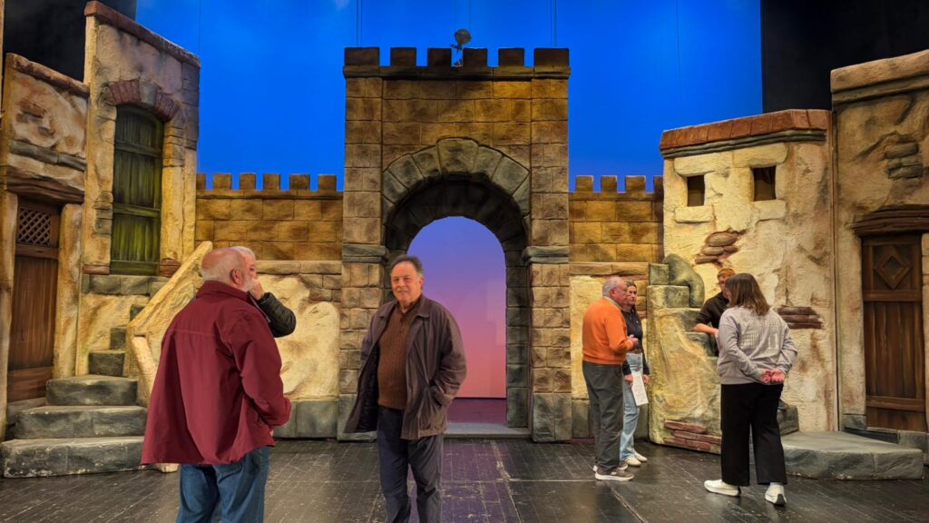 Assaig de la Passió d’Ulldecona al teatre Orfeó Montsià amb els actors i l'escenografia de la muralla.