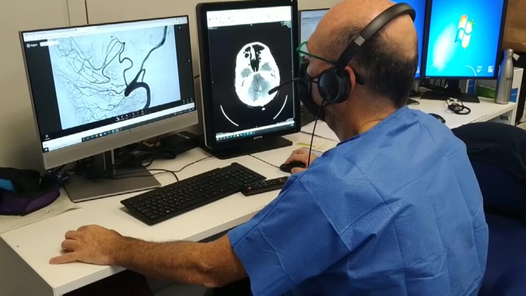Metge especialista analitzant un escàner cerebral i una angiografia en un centre hospitalari de Tarragona.