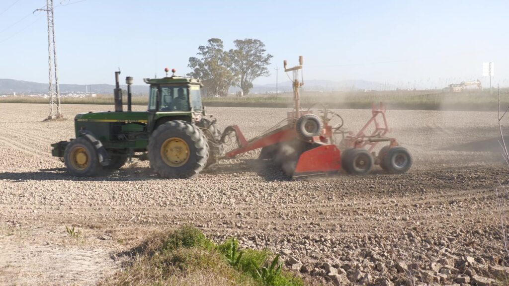 Tractor preparant els camps d'arròs a Deltebre.