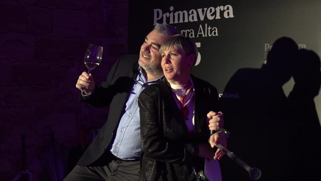 Parell de persones celebrant amb una copa de vi blanc a la gala de la Primavera DO Terra Alta a Corbera d'Ebre.