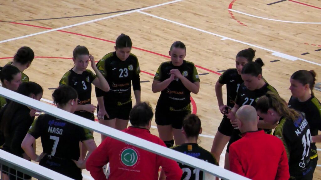 Jugadores del sènior femení del Club Handbol Amposta escoltant instruccions durant un temps mort al pavelló d'Amposta, Montsià.