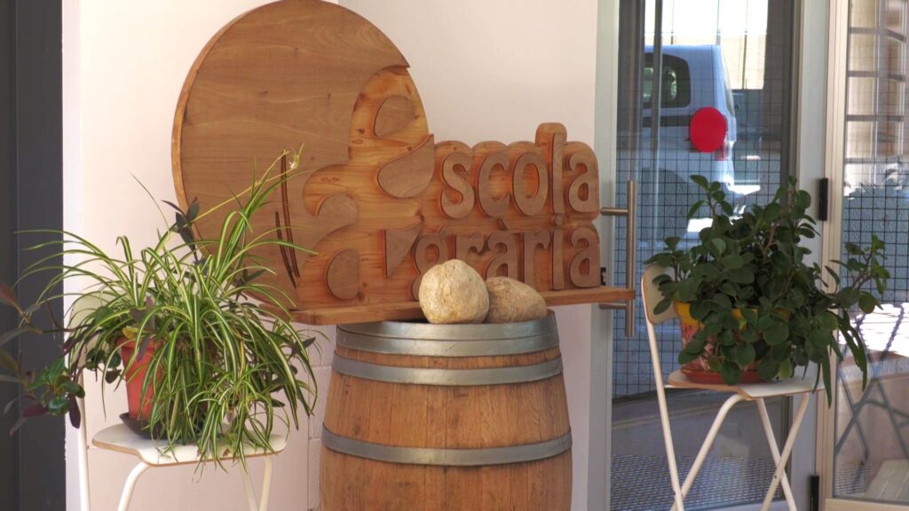 Logotip de fusta de l'Escola Agrària de Gandesa sobre una bota de vi a la Terra Alta.