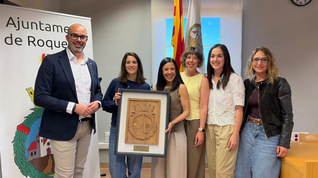 L'alcalde de Roquetes, Ivan Garcia, i representants de l'Associació de Veïns La Ravaleta amb l'escut de la ciutat a Roquetes, Baix Ebre.