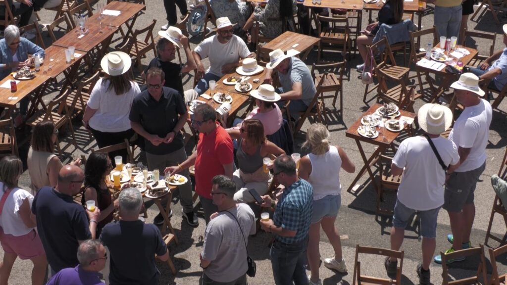 Gent dinant i tastant ostre del Delta a les taules de la Diada de l'Ostra a l'Ampolla, Baix Ebre.