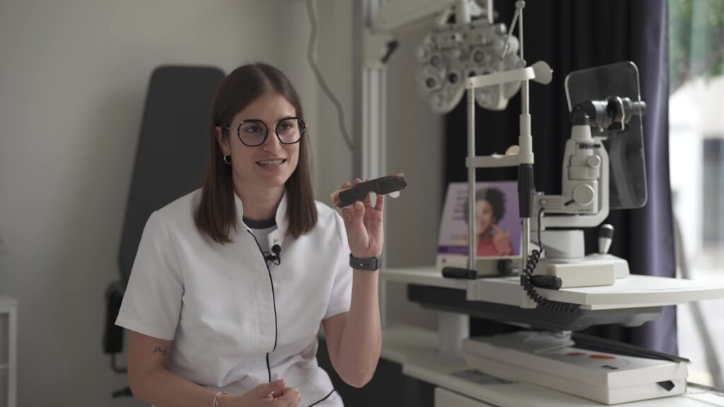 Una optometrista mostra unes ulleres especials per a l'eclipsi solar en un centre òptic de les Terres de l'Ebre.