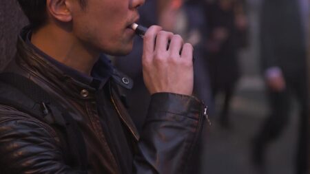 Home jove utilitzant una cigarreta electrònica al carrer a Tortosa durant la Setmana Sense Fum.