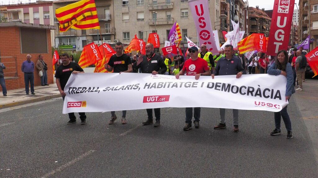Manifestació del Primer de Maig a Tortosa, Terres de l'Ebre, amb representants sindicals d'UGT, CCOO i USOC darrere d'una pancarta.