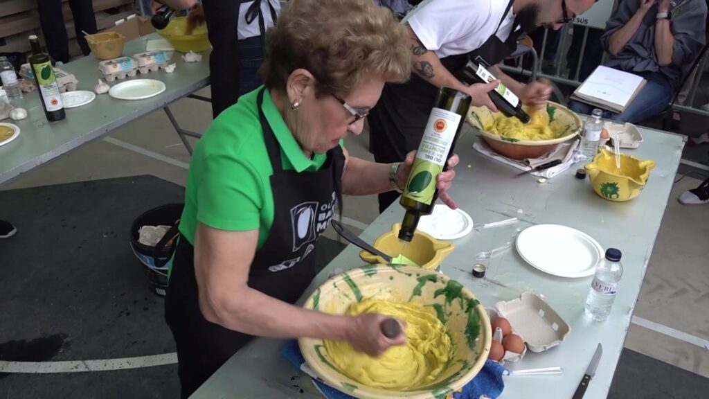 La Fira de l’Oli de de les Terres de l’Ebre torna a reunir el sector oleícola este cap de setmana a Jesús Una dona elaborant allioli a mà amb oli d'oliva verge extra en un concurs gastronòmic a la Fira de l'Oli de Jesús, Baix Ebre.