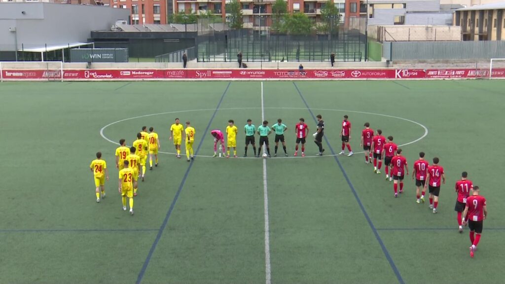 Jugadors de futbol del Tortosa-Ebre i el Juventud 25 de Septiembre formant al centre del camp a Tortosa, Baix Ebre.