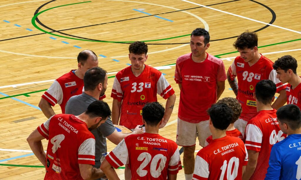 Jugadors del CE Tortosa escoltant les instruccions de David Fernández al pavelló firal de Tortosa, Baix Ebre.