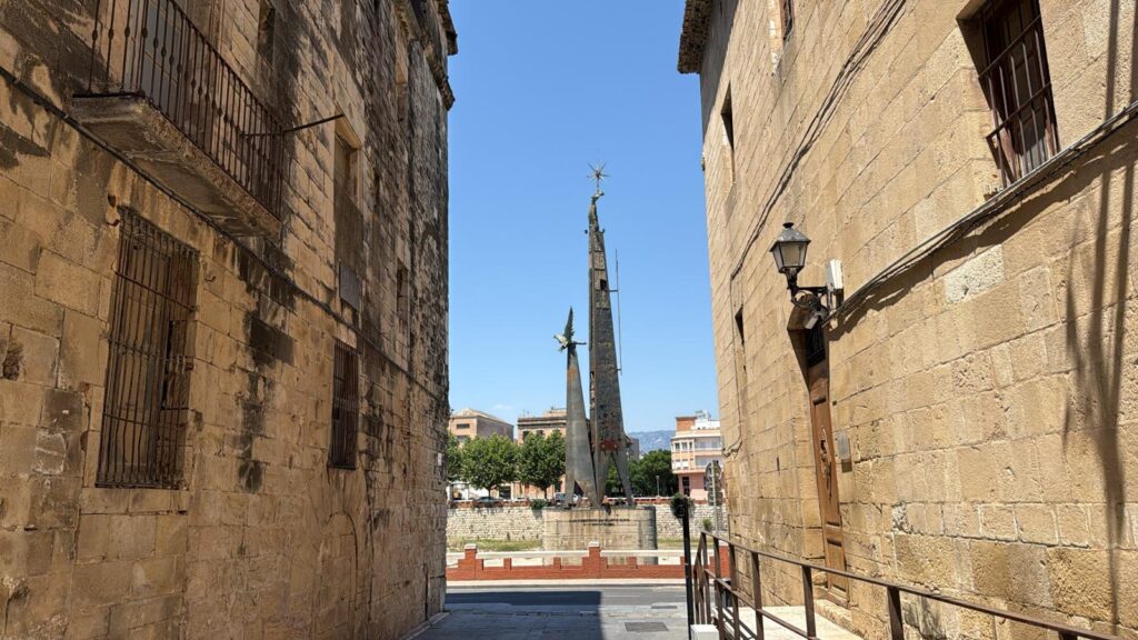 L'alcaldessa de Tortosa Mar Lleixà durant una roda de premsa amb el monument franquista al fons al riu Ebre, Baix Ebre.