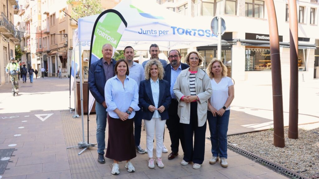 Membres de Junts per Tortosa amb Meritxell Roigé davant una carpa informativa a Tortosa, Baix Ebre.