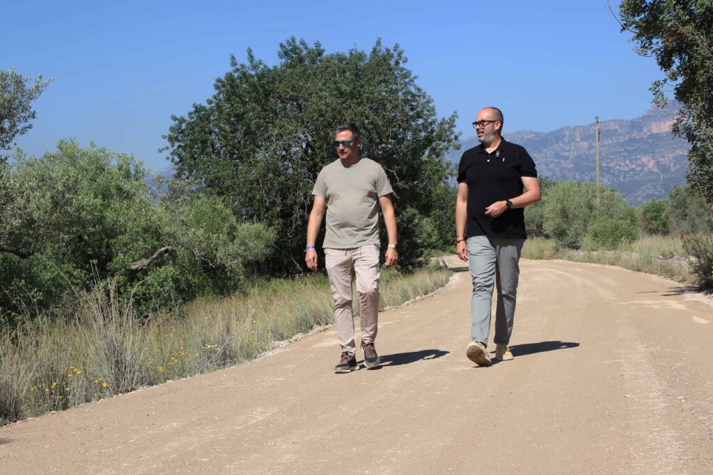 L'alcalde de Roquetes, Ivan Garcia, caminant per un camí municipal reformat al Baix Ebre juntament amb un acompanyant.