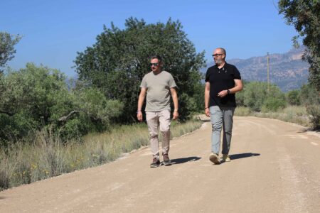 L'alcalde de Roquetes, Ivan Garcia, caminant per un camí municipal reformat al Baix Ebre juntament amb un acompanyant.