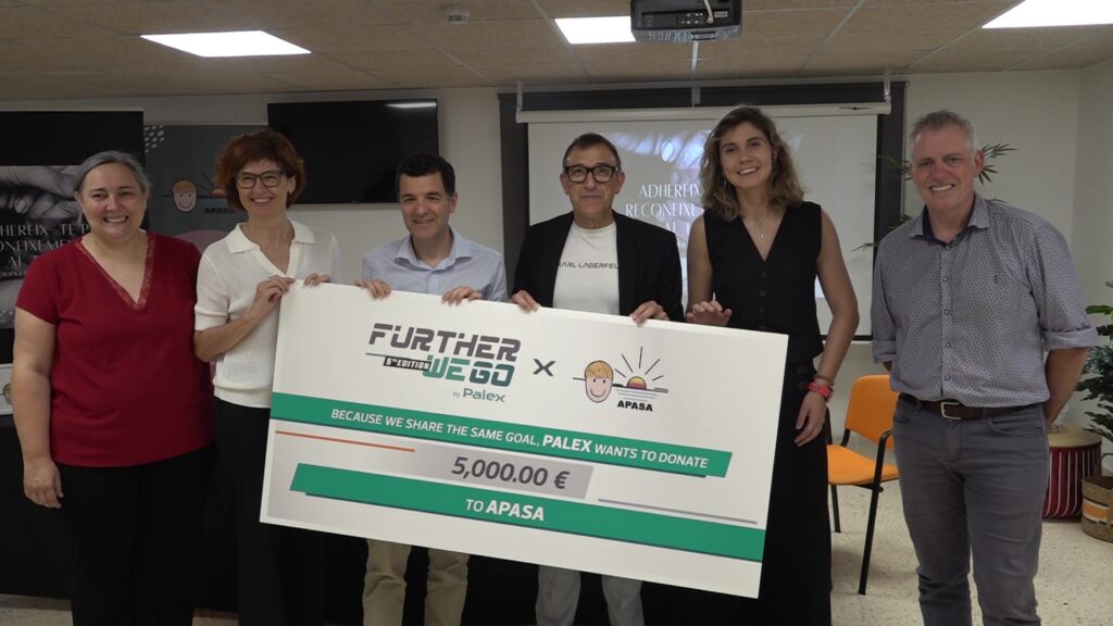 Representants del consistorí ampostí, d’APASA i del Grup Palex sostenen un xec de 5.000 euros del programa Further We Go