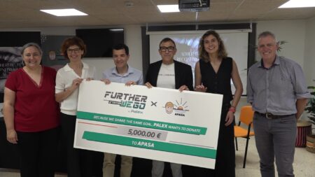 Representants del consistorí ampostí, d’APASA i del Grup Palex sostenen un xec de 5.000 euros del programa Further We Go