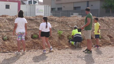 Alumnes i operaris plantant vegetació autòctona al talús de Carvallo a l'Aldea, Baix Ebre.
