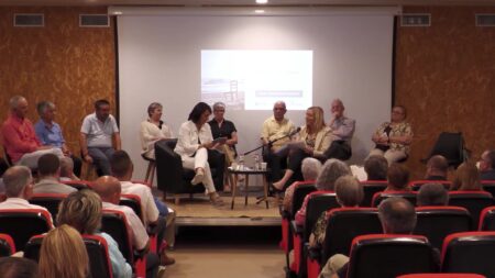 Diversos testimonis i familiars asseguts a l'escenari compartint relats durant l'Audiència Memorial a Benifallet.