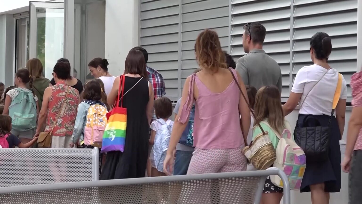 Famílies i alumnes esperant a les portes d'un centre educatiu públic climatitzat a les Terres de l'Ebre