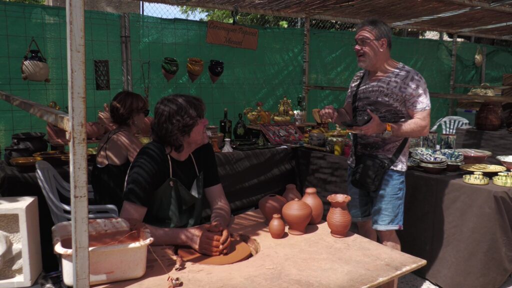 El Pinell de Brai reivindica els oficis tradicionals en la XV edició de PinellArt Fira d'artesania PinellArt amb un artesà de la ceràmica modelant el fang en un torn en un estand al carrer al Pinell de Brai, Terra Alta.