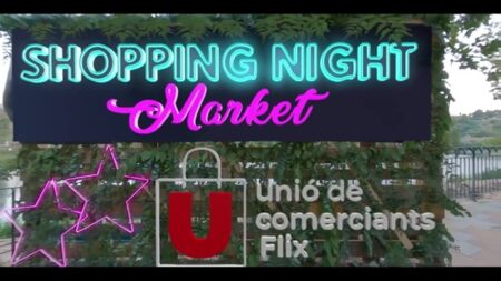 Cartell lluminós de neó de la Shopping Night Market organitzada per la Unió de Comerçants de Flix al passeig de l'Ebre.