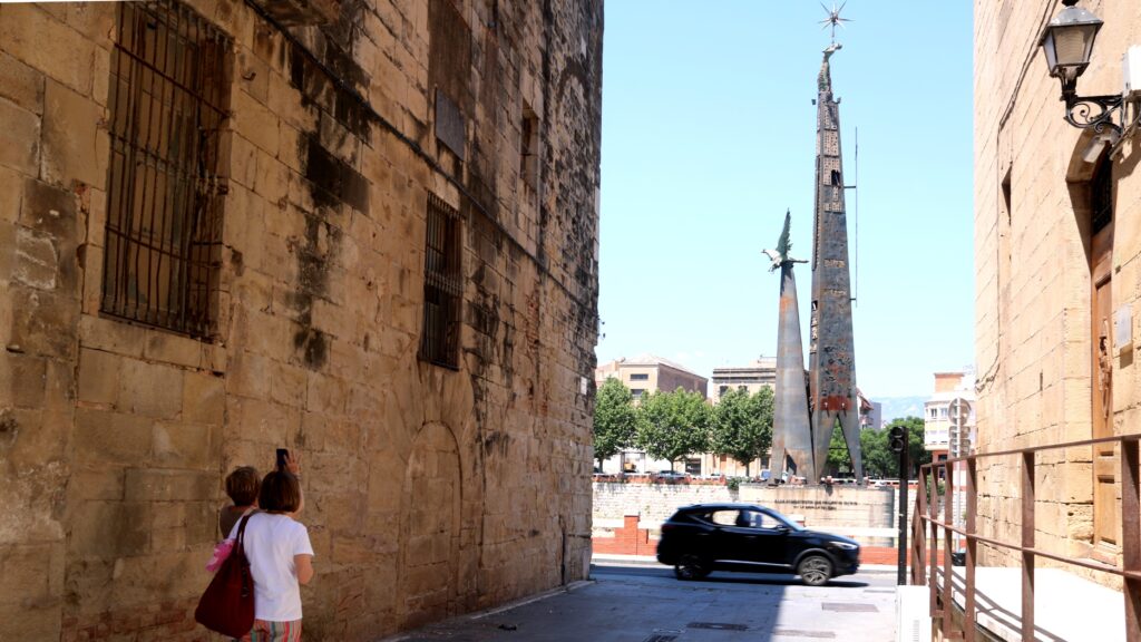 Dues persones mirant el monument franquista de Tortosa situat al mig del riu Ebre al Baix Ebre
