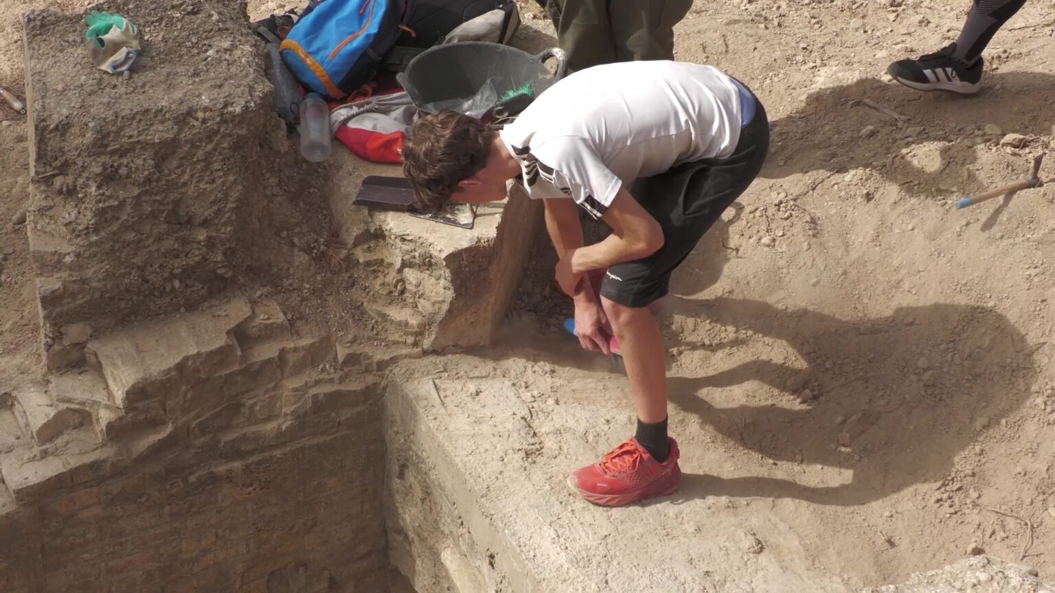 Un jove participant realitzant tasques d'excavació arqueològica a les trinxeres de Caseres.
