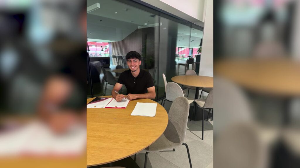 Hugo Garví assegut a la taula firmant el seu contracte de renovació amb el RCD Mallorca.