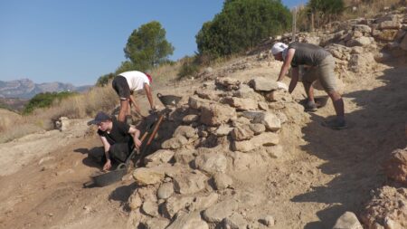 Arqueòlegs de la Universitat Rovira i Virgili treballant en l'excavació d'estructures defensives de pedra al jaciment protohistòric de l'Assut de Tivenys, al Baix Ebre