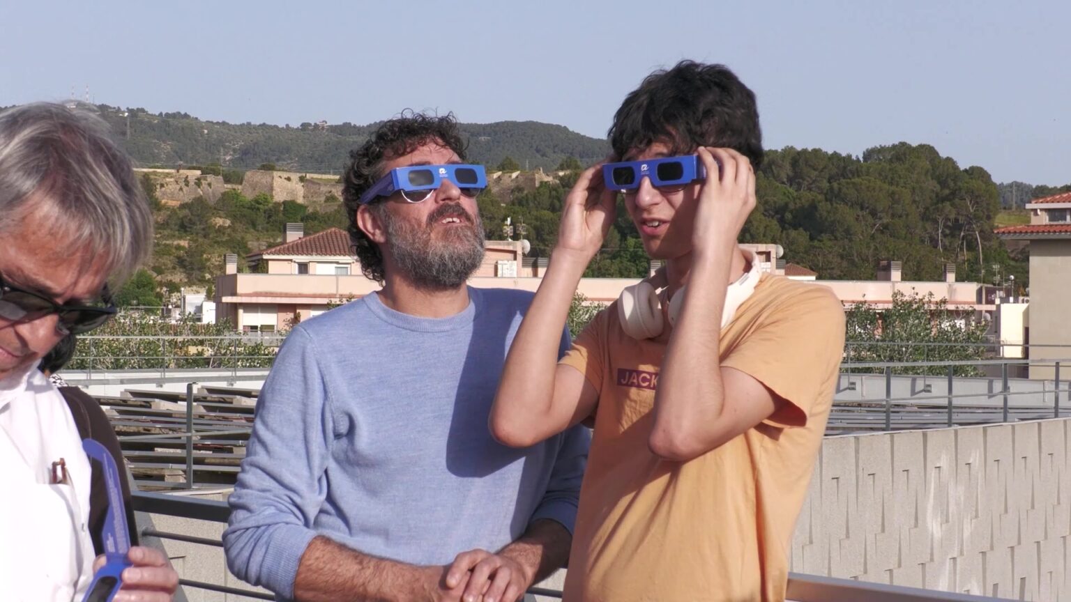 Dos hòmens observen el Sol amb ulleres de protecció homologades especials per a eclipsis des d'un terrat a Tortosa.