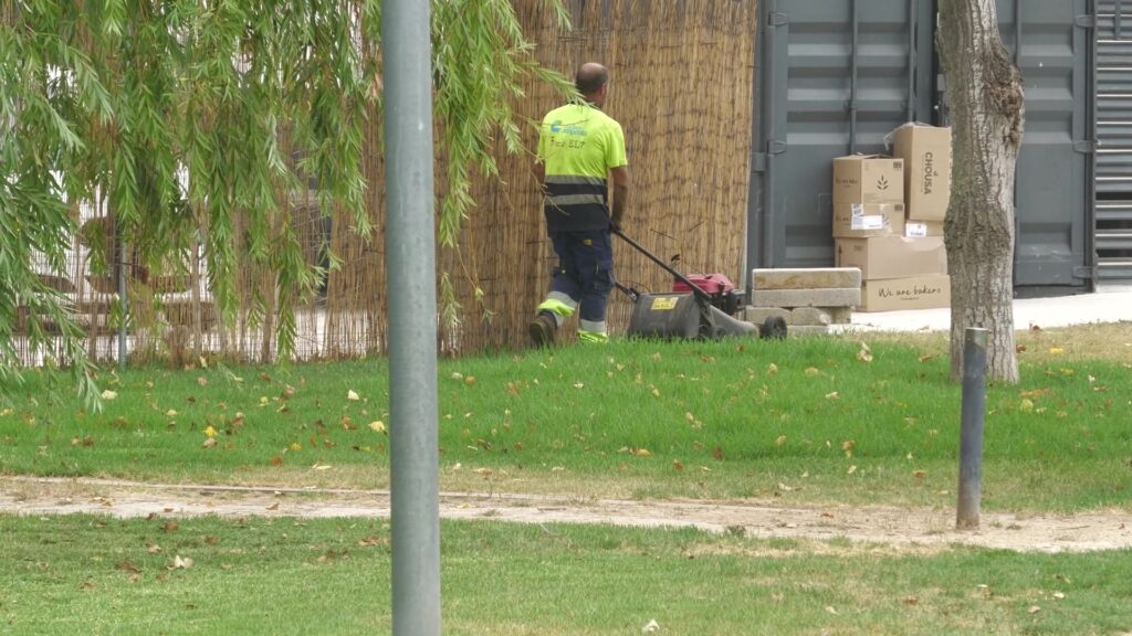 Operari de jardineria treballant amb un tallagespa en una zona verda d'Amposta