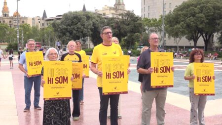 Membres de l'ANC i Òmnium Cultural mostrant els cartells de la convocatòria de la Diada