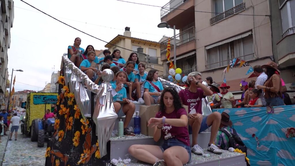 Jesús viu una multitudinària desfilada del Gran Cosso Iris amb una vintena de carrosses Carrossa engalanada plena de jóvens llançant confeti durant el Gran Cosso Iris de les festes majors de Jesús, Terres de l'Ebre.