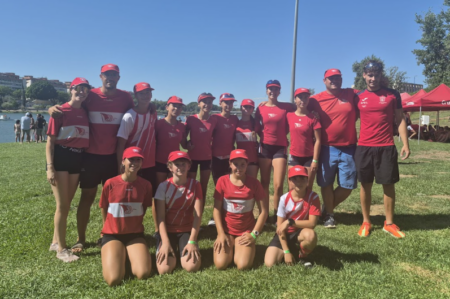 Equip aleví i infantil del Club de Rem Tortosa posant amb samarretes roges en una zona verda al Campionat d'Espanya de Rem.