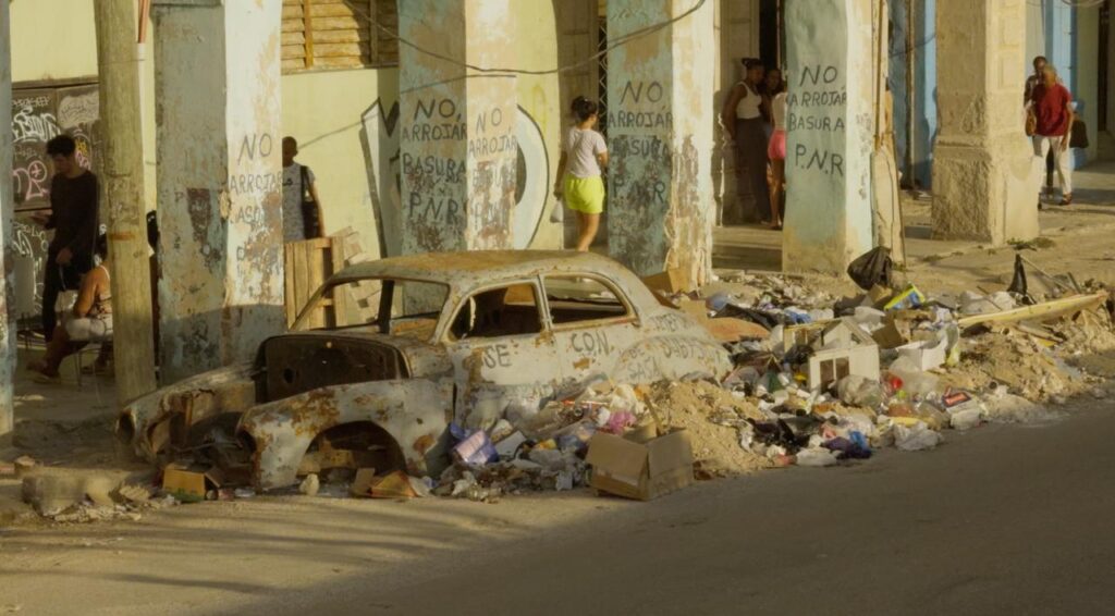 Carrer degradat de Cuba amb deixalles i un cotxe clàssic abandonat en un reportatge de la productora de les Terres de l'Ebre Filmsnòmades.